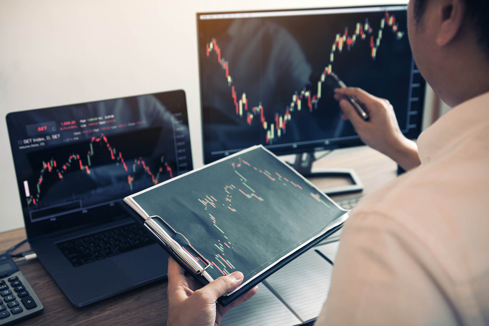 Investor man analyzing the graph of the stock market using a pen